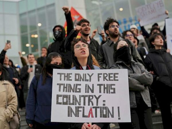 Student holds placard saying "The only free thing in this country is inflation"