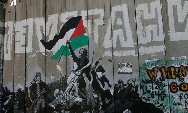 Woman holds Palestinian flag on shoulders of other demonstrators