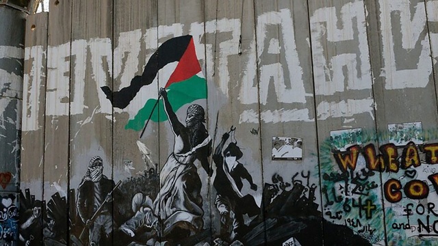 Woman holds Palestinian flag on shoulders of other demonstrators