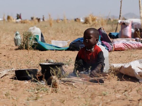 Child sitting in Sudanese desert