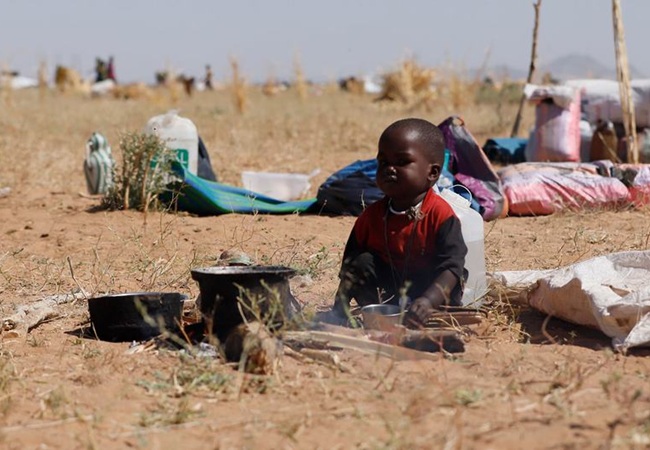 Child sitting in Sudanese desert